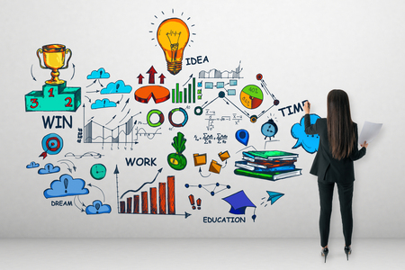 Back view of young businesswoman drawing creative business sketch on concrete wall. Idea and money conceptの写真素材