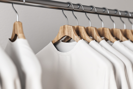 Row of white tees on hangers. Concrete wall background. Style and design concept. 3D Renderingの写真素材