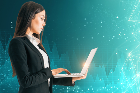 Side view of attractive young european adult using laptop on abstract blue background with digital interface. Innovation and finance conceptの写真素材