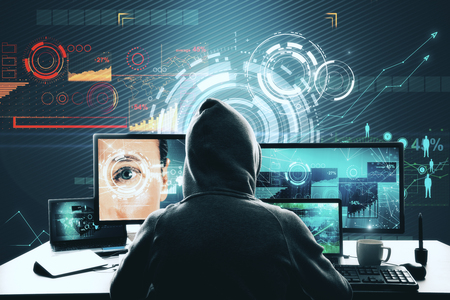 Hacker at desk using computer with glowing interface. Malware, Face ID and access conceptの写真素材