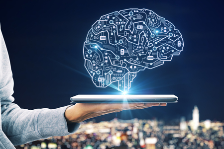 Close up of hand holding device with glowing circuit brain hologram on blurry city background. AI and robotics conceptの写真素材