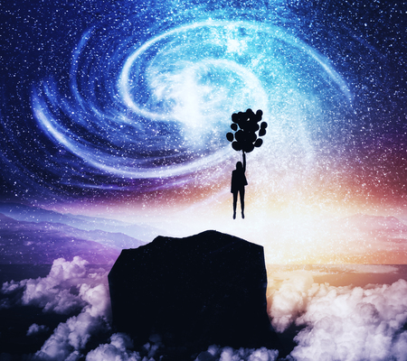 Back view of young backlit businesswoman flying with balloons on abstract starry sky space and cliff background. Freedom and fiction conceptの写真素材