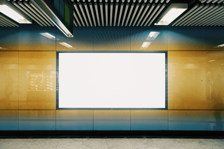 Front view of empty white underground poster on orange wall. Advertisement and urban concept. Mock upの写真素材