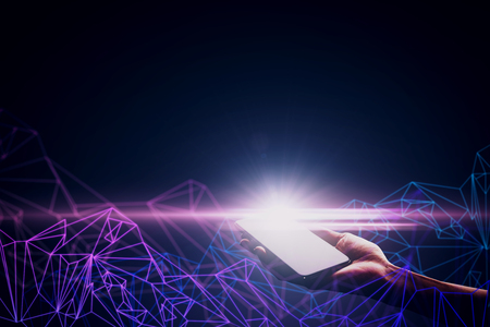 Hand holding glowing smartphone with digital pattern on black background. Technology and communication concept.の写真素材