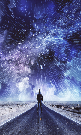 Back view of man on creative road with cloudy night sky background. Freedom and opportunity conceptの写真素材