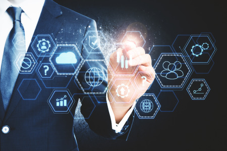 Close up of businessman hand using digital business interface on dark background. Innovation and finance concept. Double exposureの写真素材