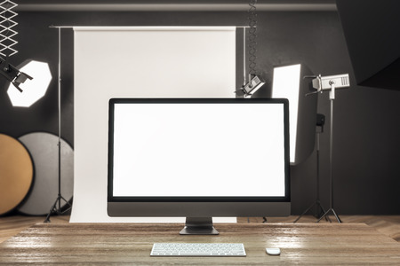Close up of creative designer desktop with blank white computer screen in modern studio interior. Mock up, 3D Renderingの写真素材
