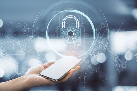 Hand holding smartphone with creative polygonal padlock interface on blurry background. Internet and safety concept. Double exposureの写真素材