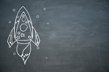 Creative rocket sketch on chalkboard wall background. Startup and entrepreneurship conceptの写真素材