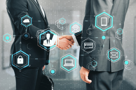 Side view of businessmen shaking hands in blurry office interior with digital interface. Social network and partnership concept. Double exposureの写真素材