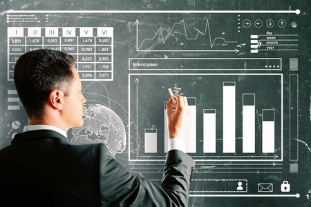 Businessman drawing creative business sketch on chalkboard wall. Finance and economy conceptの写真素材