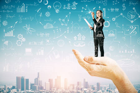 Abstract hand holding businesswoman with business sketch on blue sky and city background. Success and finance concept. Double exposureの写真素材