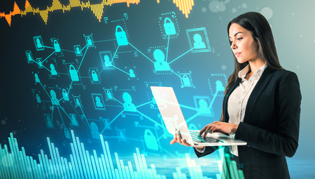 Side view of attractive young european businesswoman using laptop with glowing business interface on...