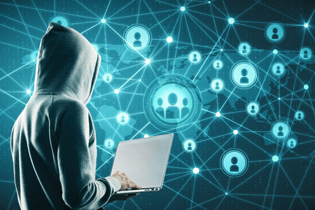 Social network and malware concept. Hacker using laptop with glowing connections on blue digital mapの写真素材