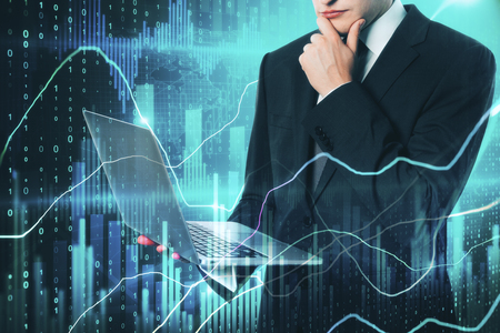 Attractive european businessman using laptop with forex chart on blurry binary code background. Technology and stock concept. Double exposureの写真素材
