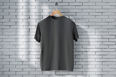 Hanger with empty black t-shirt hanging on brick wall background with sunlight. Shop print ad concept. Mock up, 3D Renderingの写真素材
