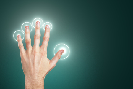 Hand using glowing screen on blue background. Innovation and hud conceptの写真素材