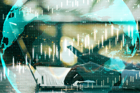 Side view of hands using laptop and smartphone with forex chart and globe. Global trade and finance concept. Double exposureの写真素材