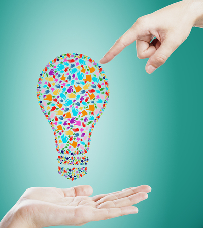 Held hand gesture lightbulb on blue background. Communication, community, inspire, idea and innovation conceptの写真素材