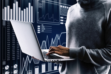 Malware and hud concept. Side view of hacker using laptop with digital business interface on blurry backgroundの写真素材