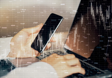 Analytics and trade concept. Side view of hands using notebook and smartphone with glowing forex...