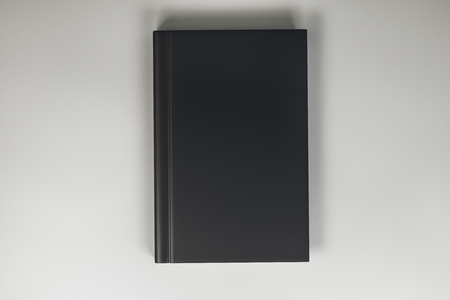 Clean closed black hardcover book on light background. Close up. Publish and info concept. Mock up, 3D Renderingの写真素材