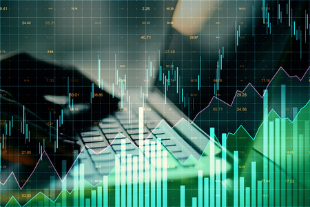 Close up of hands using laptop with glowing forex chart on blurry background. Invest and stats concept. Multiexposure