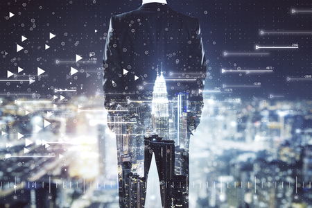 Back view of young businessman on bright night Kuala Lumpur city background with big data background. Technology and internet concept. Multiexposureの写真素材