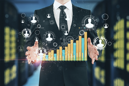 Businessman hands holding creative social network graph on blurry server room background. Networking and trade concept. Double exposureの写真素材