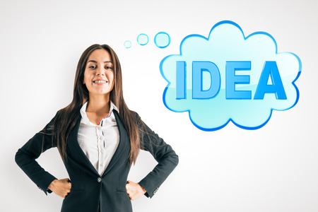 Happy young businesswoman thinking about idea on white wall background. Innovation and solution conceptの写真素材