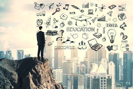 Success and science concept. Businessman standing on cliff with creative education sketch on modern city background. Multiexposureの写真素材