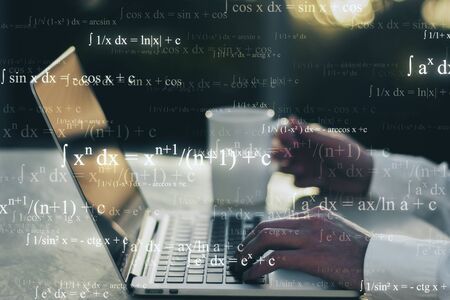 Programming and work concept. Close up of hands using blurry laptop and smartphone with mathematical formulas. Double exposureの写真素材