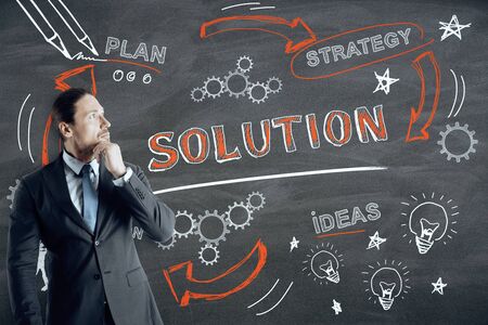 Success, finance and solution concept. Businessman drawing creative business sketch on chalkboard...