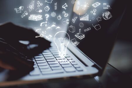 Close up of backlit hands using laptop with creative digital business sketch on blurry background. Technology, software and idea concept. Multiexposureの写真素材