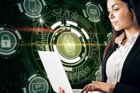 Attractive young european businesswoman using laptop with creative finger print interface on blurry...