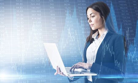 Portrait of thoughtful young businesswoman using laptop with creative glowing business graph on...