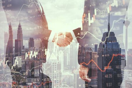 Businessmen shaking hands on abstract Kuala Lumpur city background with forex chart. Partnership and invest concept. Double exposureの写真素材