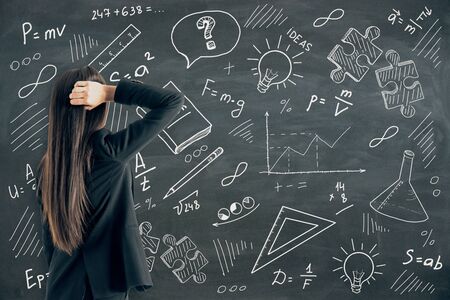 Knowledge and science concept. Businesswoman looking at creative hand drawn educational sketch on...