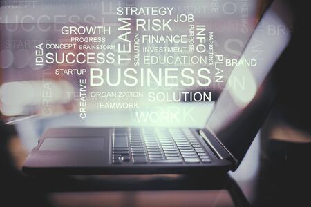 Laptop with abstract business text on blurry background. Technology and success concept. Multiexposureの写真素材