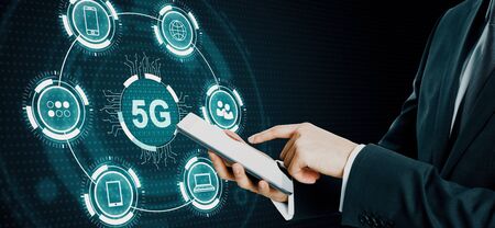 Hand using cellphone with abstract 5G interface with computing icons on dark background. Internet speed and ai conceptの写真素材