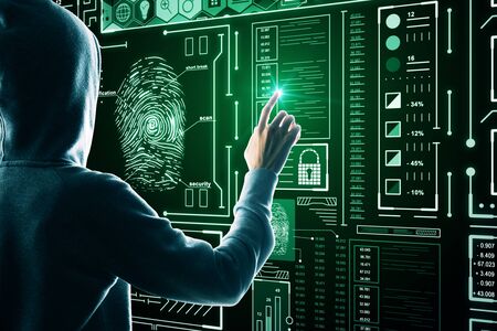 Hacker using abstract glowing finger print interface on dark background. Access and malware concept