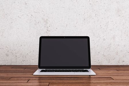 Empty laptop computer display on wooden desktop and black wall background. Online advertisement concept. Mock up, 3D Renderingの写真素材