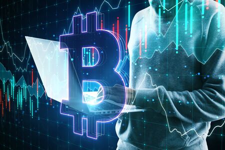 Hacker holding laptop with abstract bitcoin icon on dark background. Cryptocurrency and payment...
