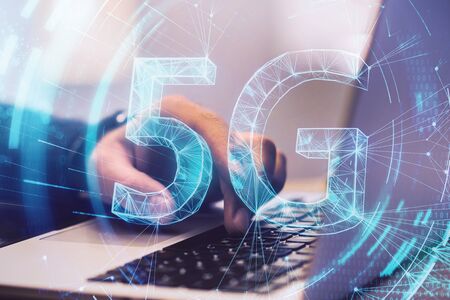 5G network concept with 5G hologram sign and man hand typing on laptop keyboard. Double exposure.の写真素材