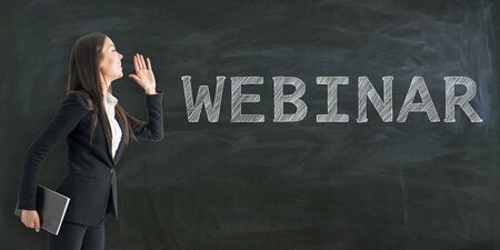 Portrait of pretty young businesswoman with creative webinar sketch on chalkboard background with text. Online education conceptの写真素材