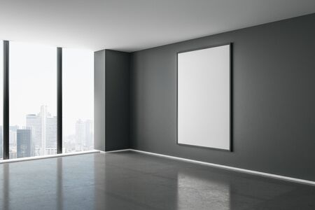 Blank white mock up poster on dark wall in modern empty room with concrete floor and city view. 3D Renderingの写真素材