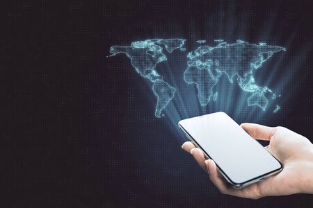 Globalization concept with digital world map from smartphone in human hand at abstract background.の写真素材