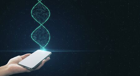 Genetic engineering and analysis concept with digital dna spiral and human hand with smartphone at abstract technology background.の写真素材