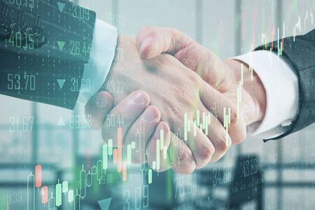 Partnership concept with double exposure of businessman handshake and abstract financial chart.