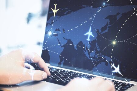 hands on desktop using laptop with airplane flight schemeの写真素材